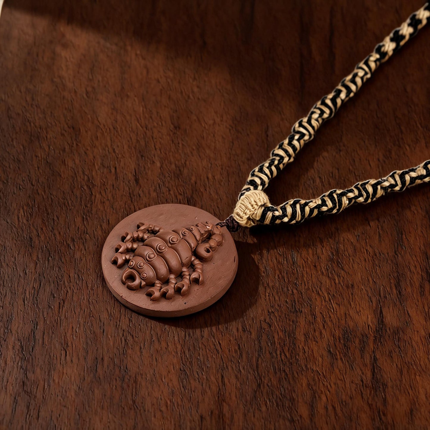 Scorpion round brown clay tsatsa pendant necklace flat lay