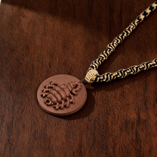 Scorpion round brown clay tsatsa pendant necklace flat lay